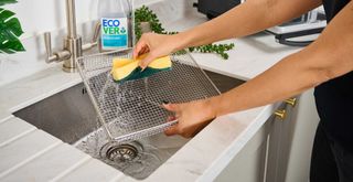 Person at a sink cleaning racks showing how to clean air fryer racks