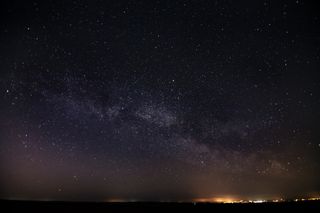 Milky Way and stars above the distant town lights above the North York Moors.