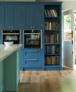 Indigo kitchen cabinets with open shelving filled with books