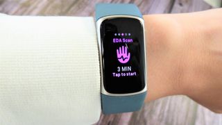 Fitbit Charge 5 på håndled med hvidt trøjeærme