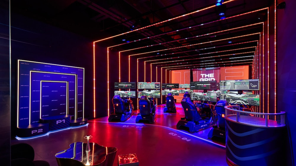 The interior of the F1 Box F1 racing simulator alit in blue and red lights. 