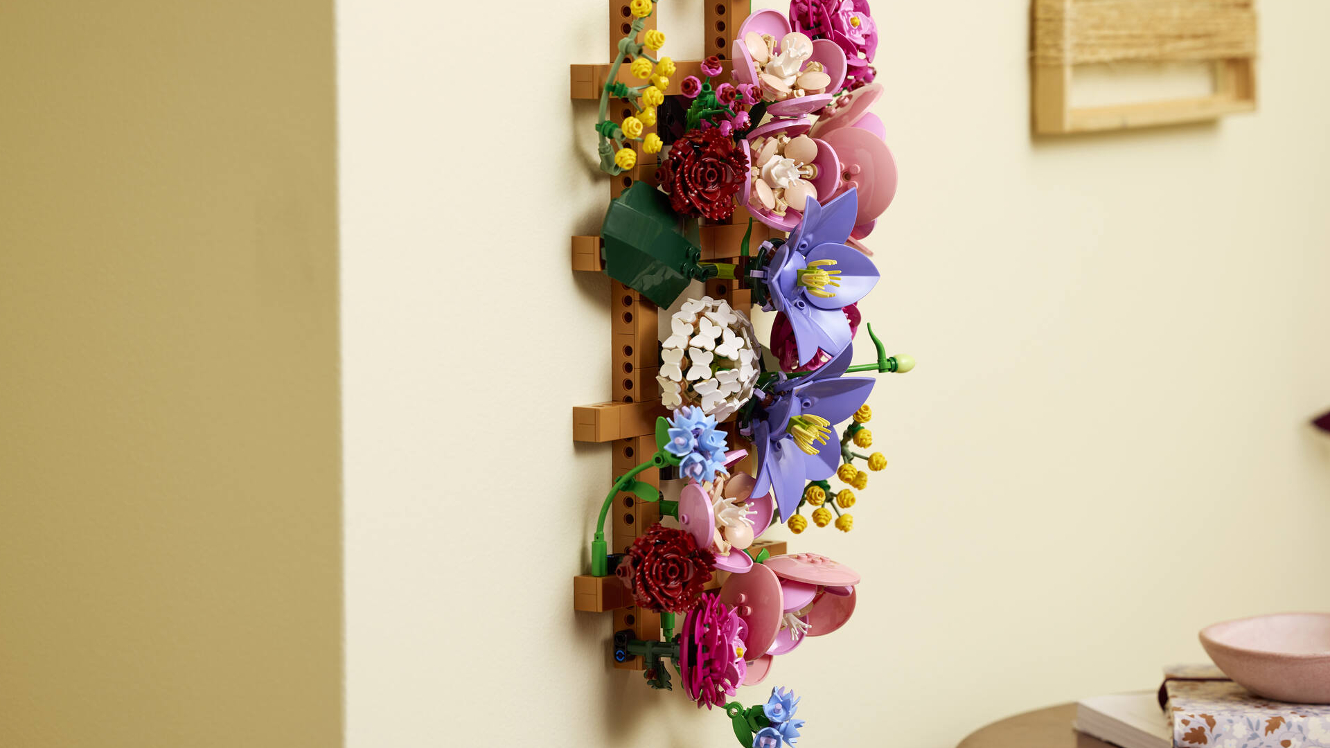 The Lego Flower Wall set shown hanging from a beige wall