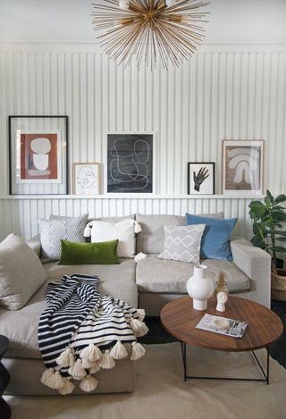 a small living room in beige with wall paneling and corner sofa by Interior Fox