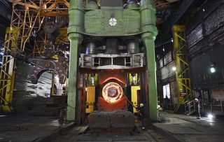 A Sheffield forge worker oversees a 100 tonne cylinder of freshly cast hot steel