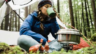 woman camping and using stove