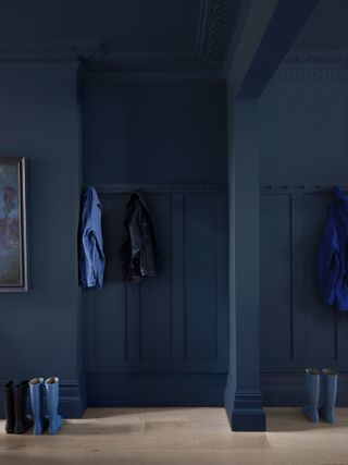 Dark blue entryway with panelled walls.