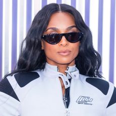 A woman with black hair wearing sunglasses and a jacket