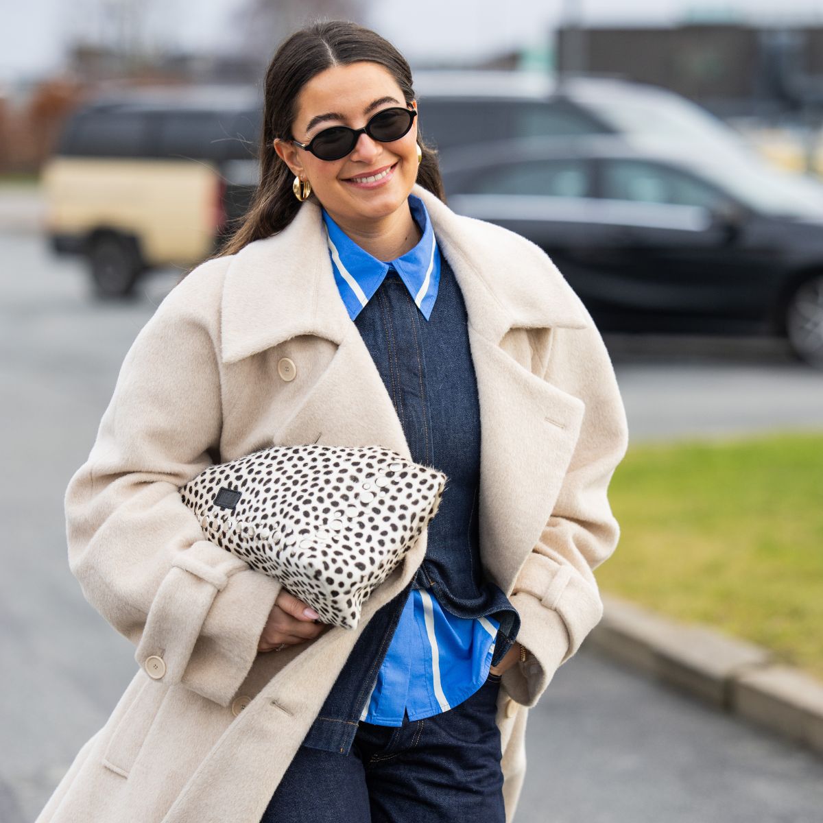 woman wearing blue shirt and cream coat