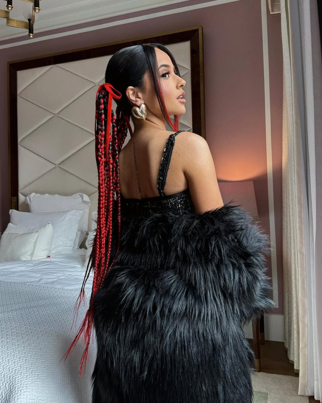 Becky G wears red and black mini braids with red bows by Justine Marjan
