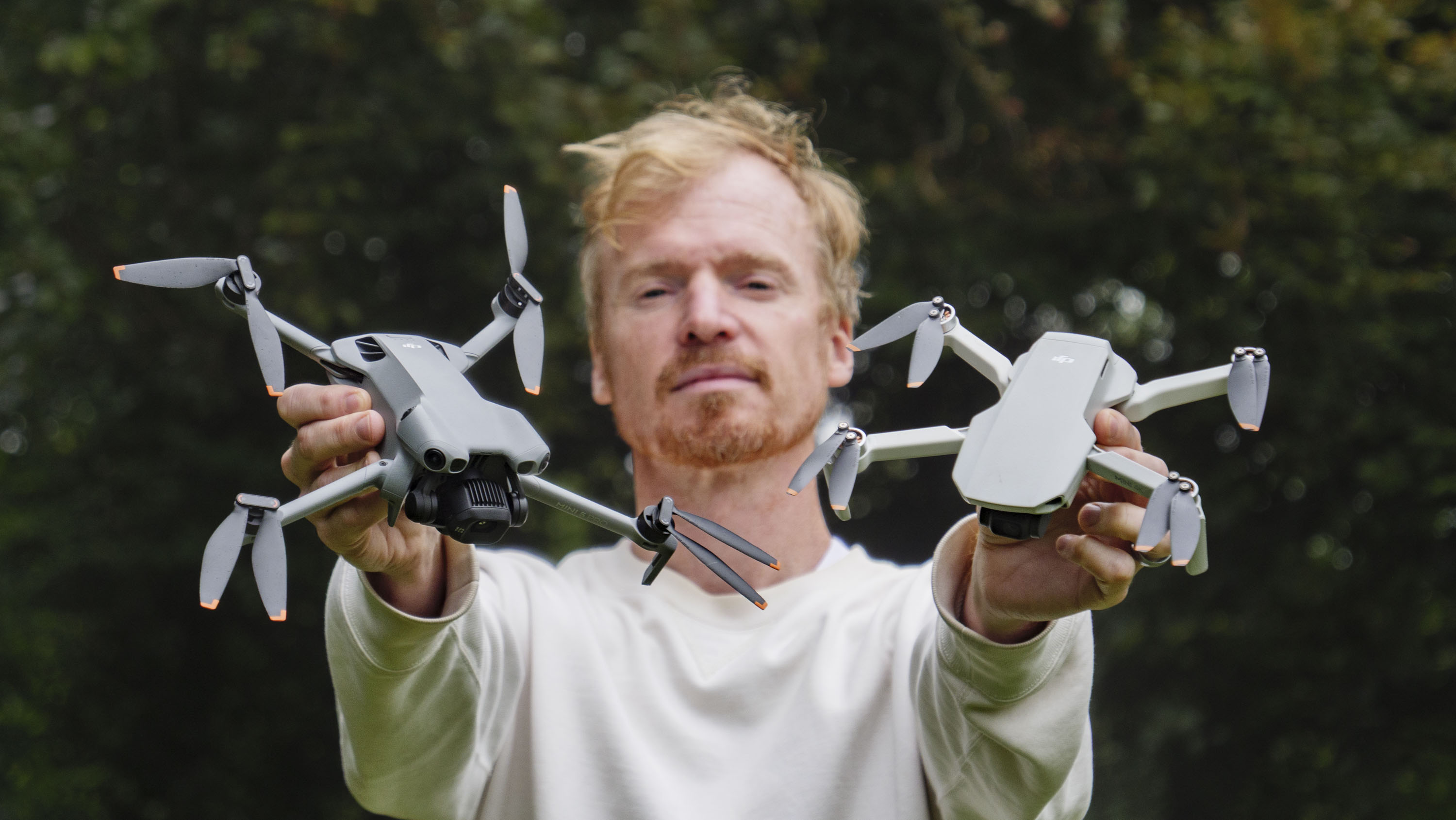 DJI Mini 5 Pro and DJI Mini 4K drones held by side by side