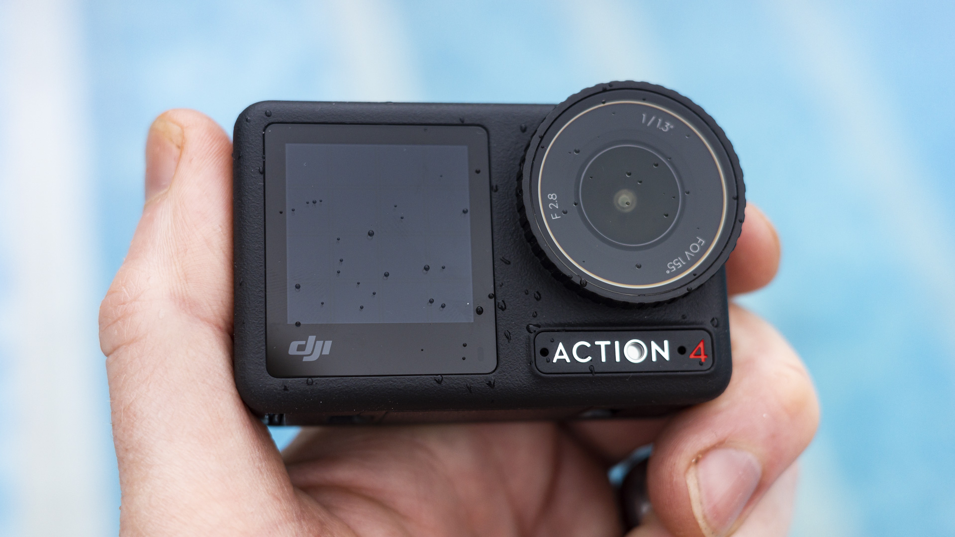 DJI Osmo Action 4 camera in the hand with swimming pool background