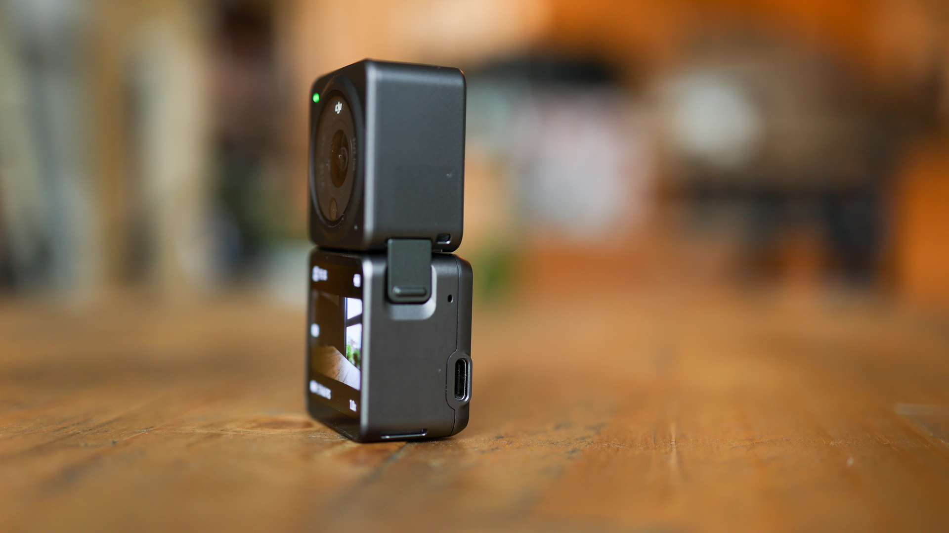 The DJI Action 2 action camera on a table with its display module