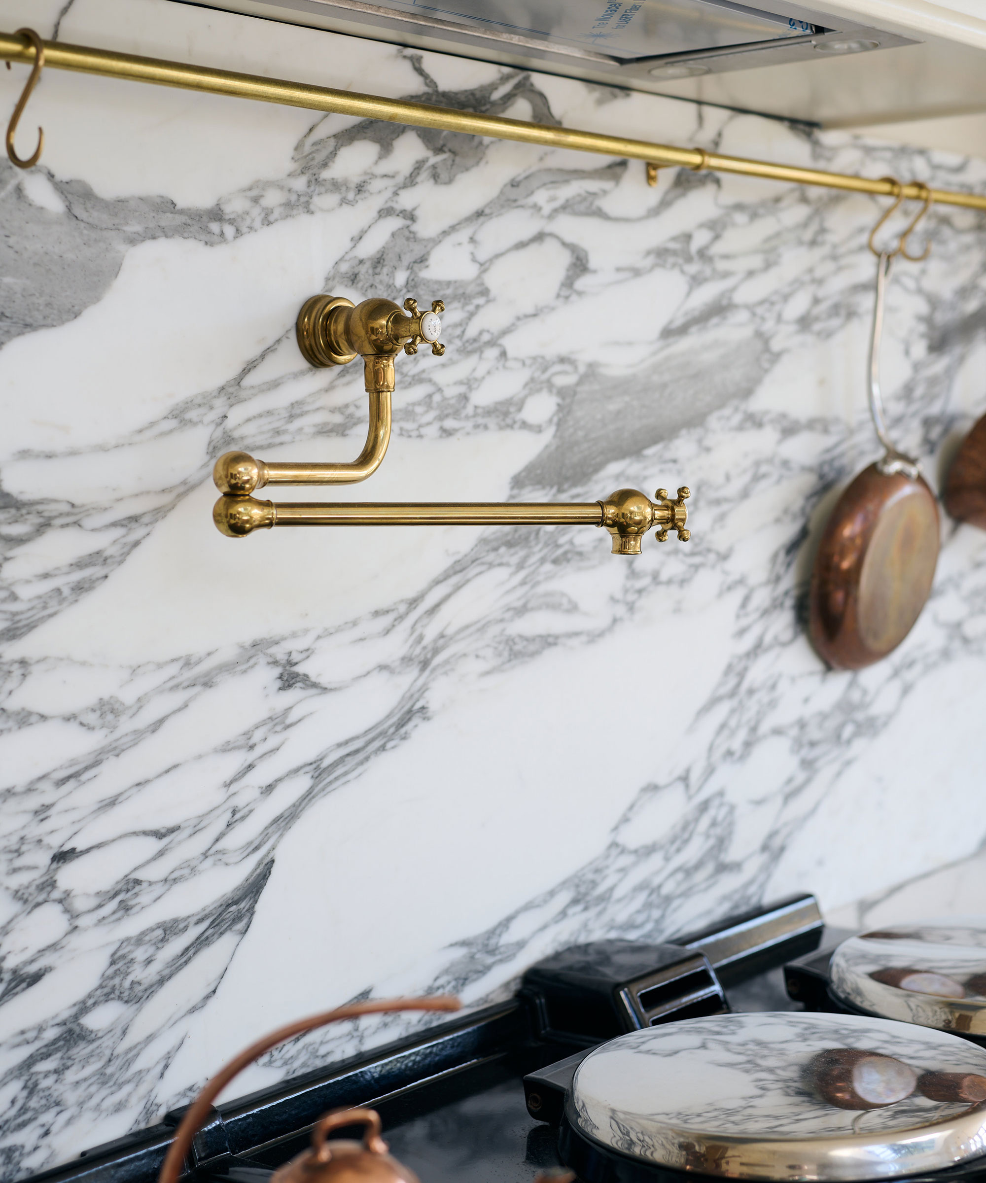 traditional style brass pot filler above AGA with marble splashback