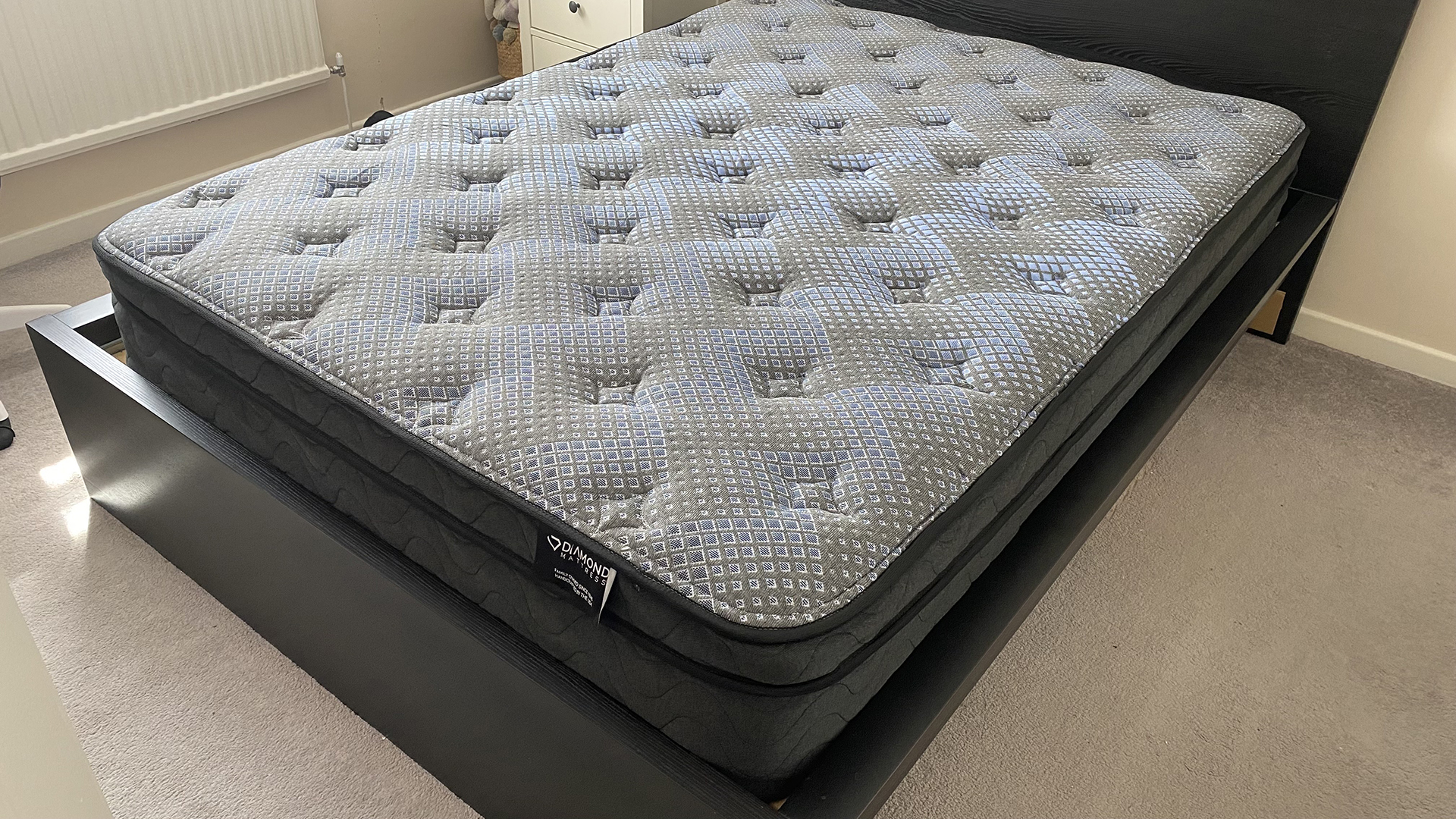 The Dreamstage Value Quilted Hybrid Mattress by Diamond mattresses, on a bed frame in our reviewer&#039;s bedroom as she prepares to test it