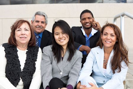 A group of employees sit outside a building. 