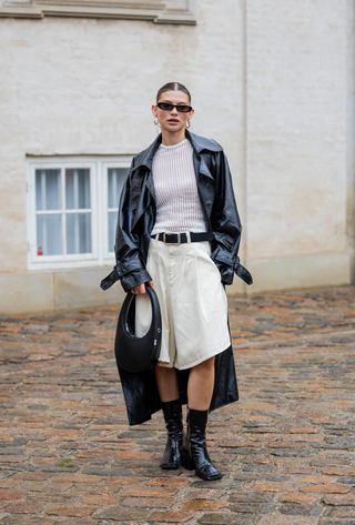 woman wearing white tank, leather jacket, and bermuda shorts