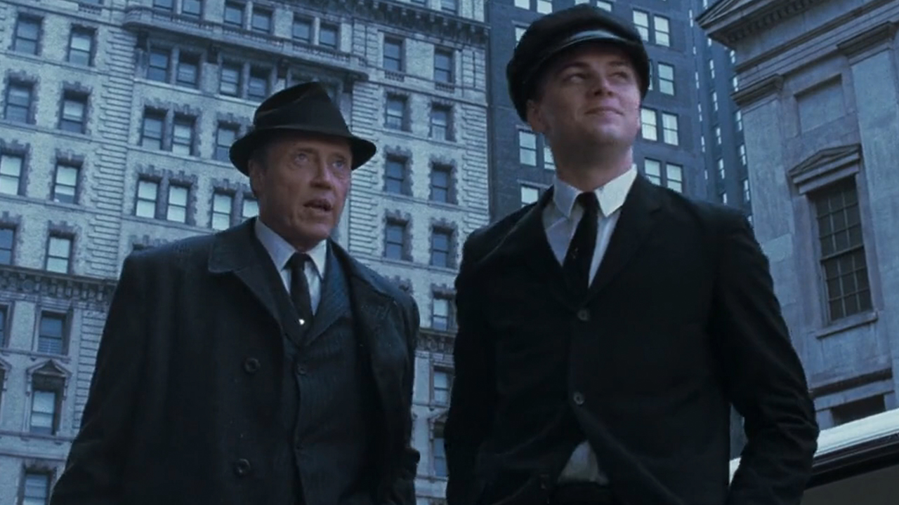 Christopher Walken in a suit standing next to Leonardo Dicaprio, also in a suit, in Catch Me If You Can