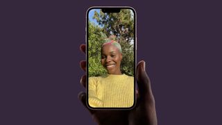 iPhone 13 en una mano mientras se hace una selfie