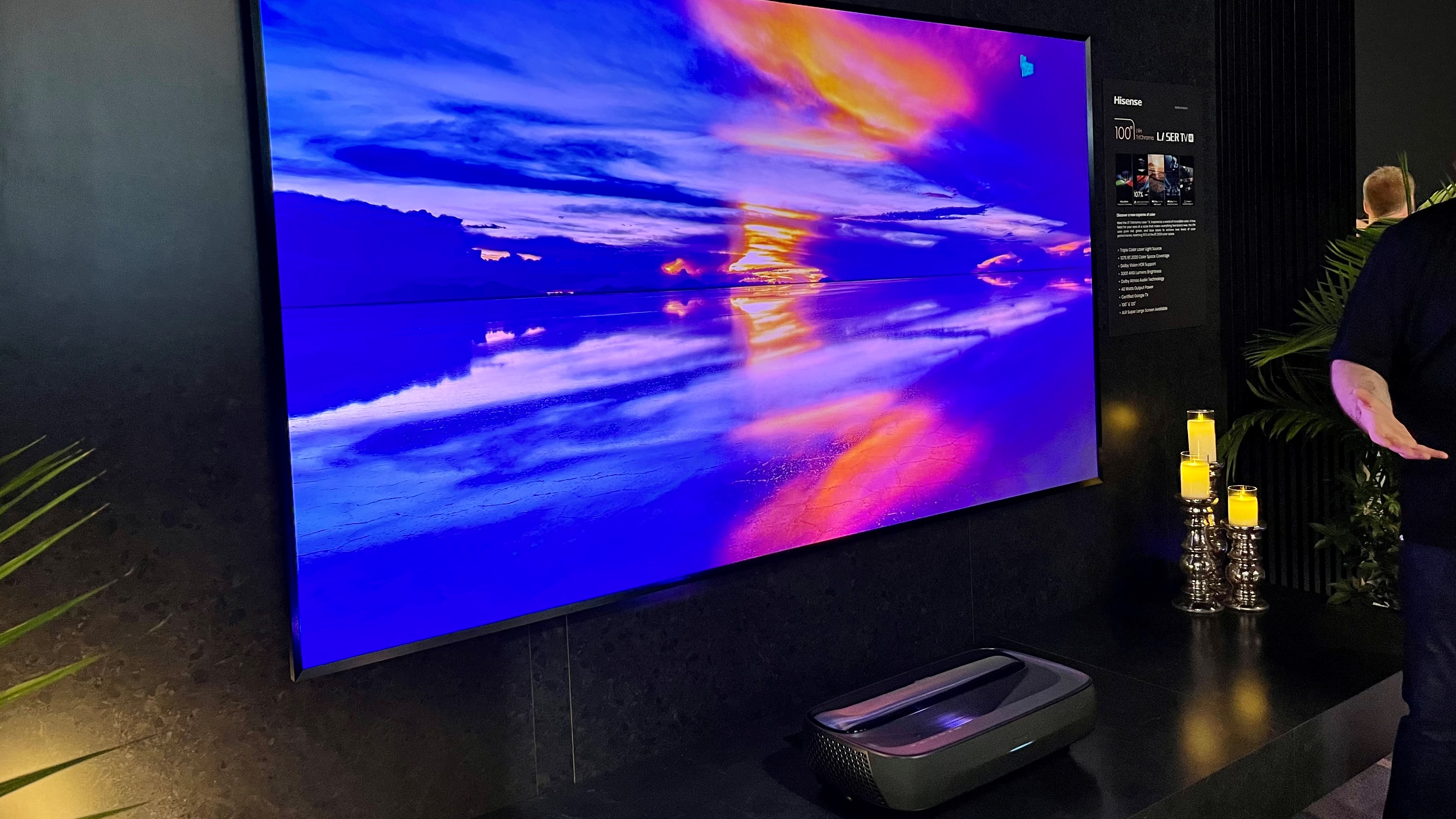 Hisense L9H tri-color laser TV screen on black wall