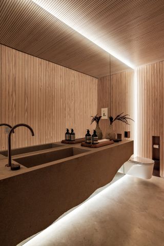 A bathroom with recessed lighting around the mirror