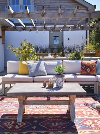 outdoor seating area with sofa and pergola lighting