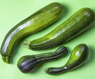 Four zucchini on a green background