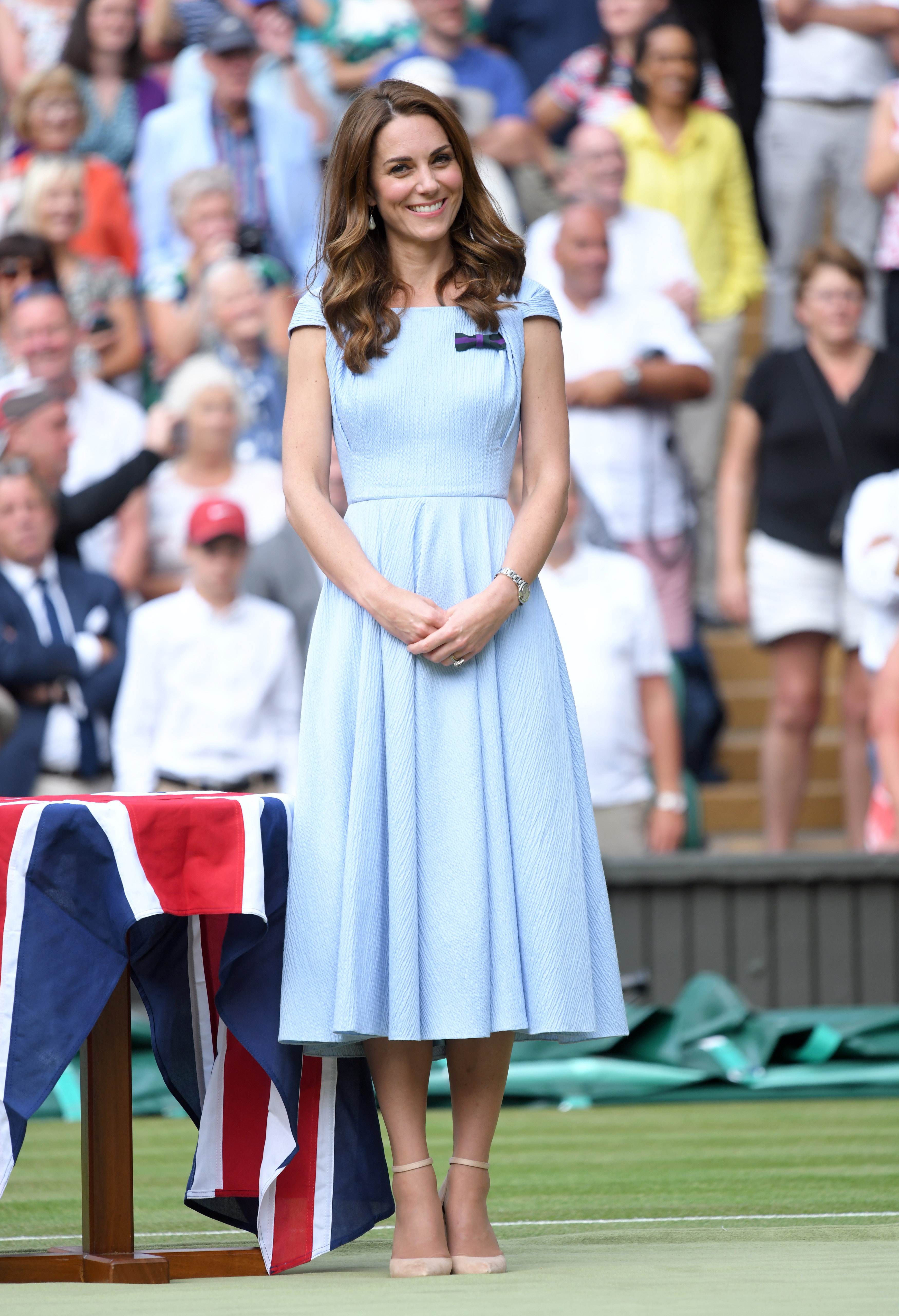 Kate Middleton wearing a blue dress and smiling at Wimbledon