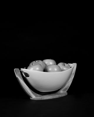 Black and white apple in bowl with black background