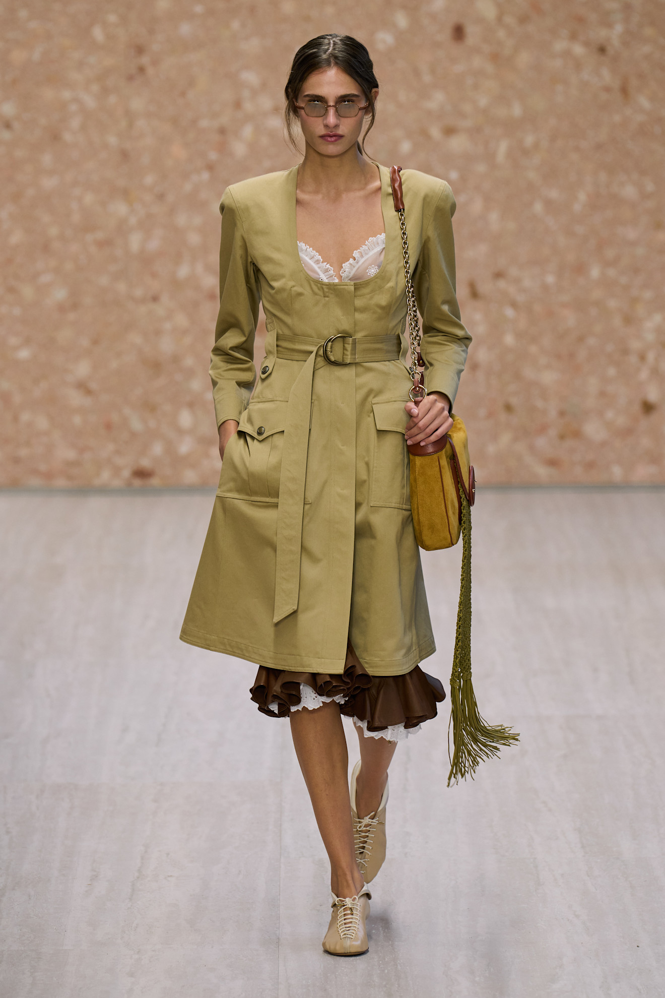 chloe spring summer 2027 runway review: model wears a camel scoop neck trench coat and lace up flats