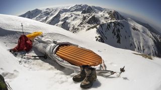 Best sleeping pad: a sleeping bag lined with a sleeping pad on a snowy mountain