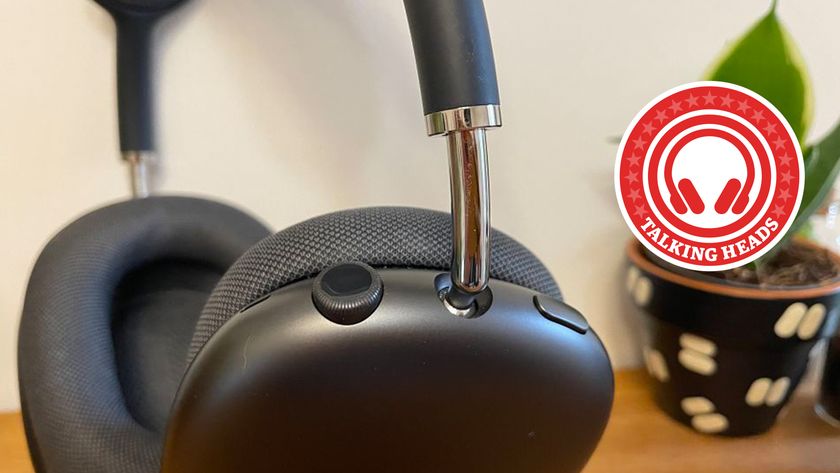 AirPods Max headphones on a desk with a plant pot in the background