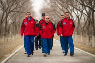 NASA astronaut Scott Kelly (center) and Russian cosmonauts Gennady Padalka (right) and Mikhail Kornienko of the Russian Federal Space Agency Roscosmos walk along the Avenue of the Cosmonauts, where two long rows of trees are each marked with the name and year of the crewmember who planted it, starting from Yuri Gagarin's tree. Photo taken on March 21, 2015, at the Baikonur Cosmodrome, Kazakhstan