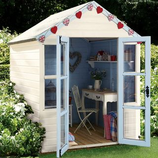 garden shed with bunting flag and desk with chair