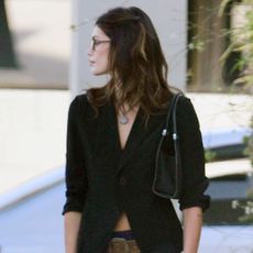 Kaia Gerber is seen at the private membership club the Living Room in Los Angeles wearing a black top, navy miniskirt, and knee-high leather boots.