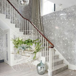 hallway with staircase and muted grey metallic walls