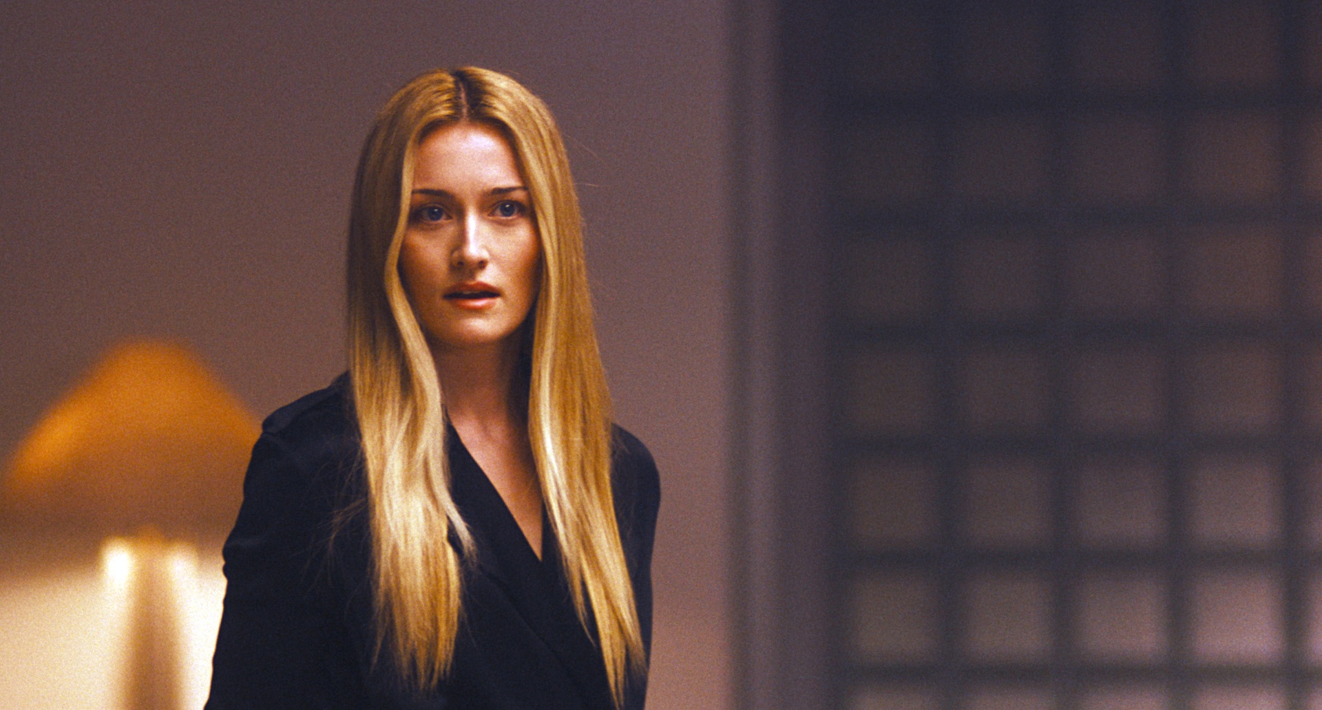 sarah pidgeon as carolyn bessette kennedy wearing a black blazer and with her blonde hair worn down in a still from the exit strategy episode of love story