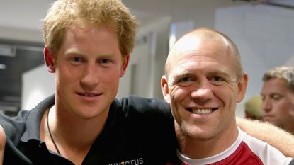 Prince Harry wears a black polo shirt and Mike Tindall wears a red soccer jersey while attending the Invictus Games 2014