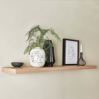 room with oak floating shelves on white wall