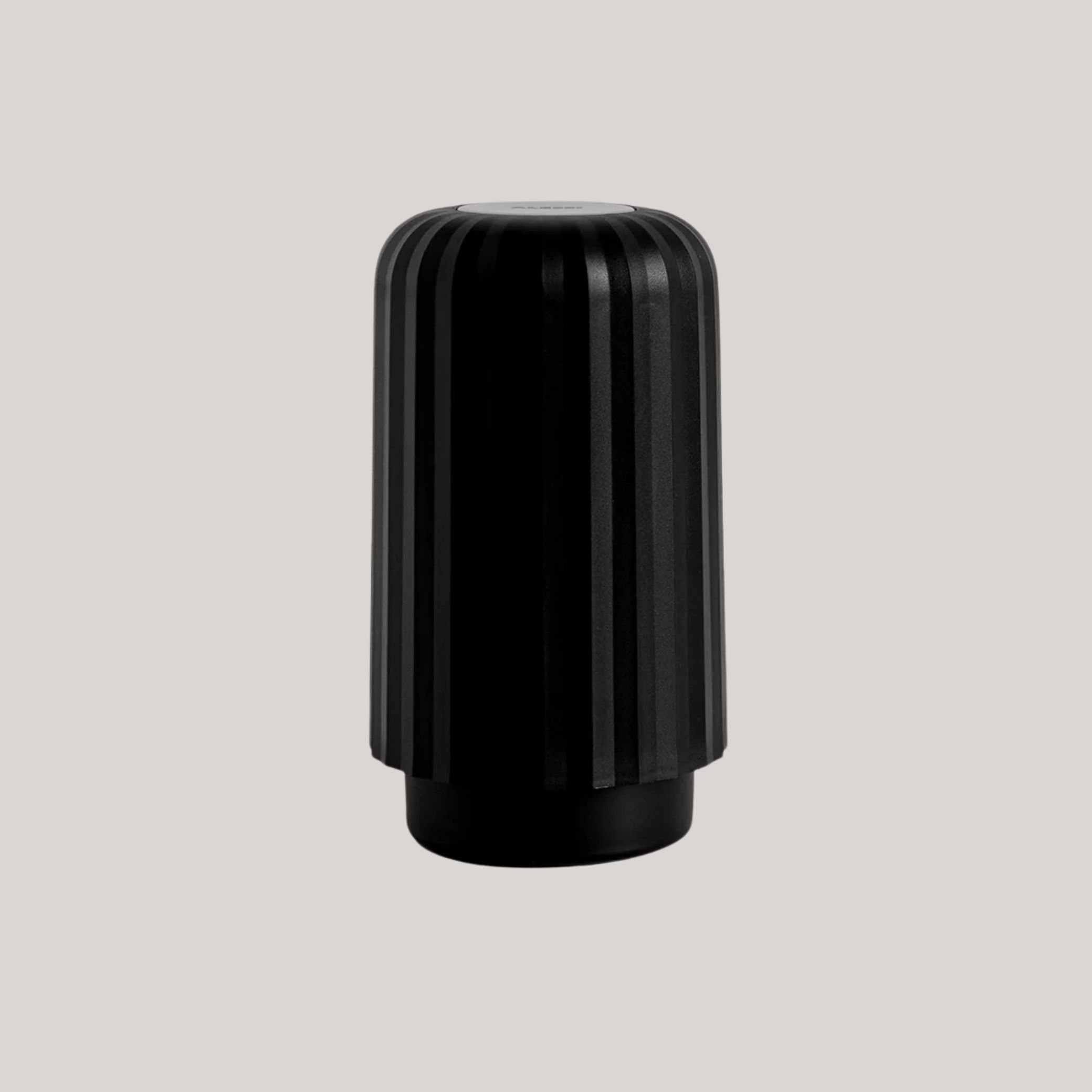 Alessi Capsule Crusher in black against pale gray background.