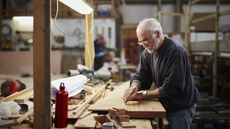 A retired man works on his hobby of woodworking.