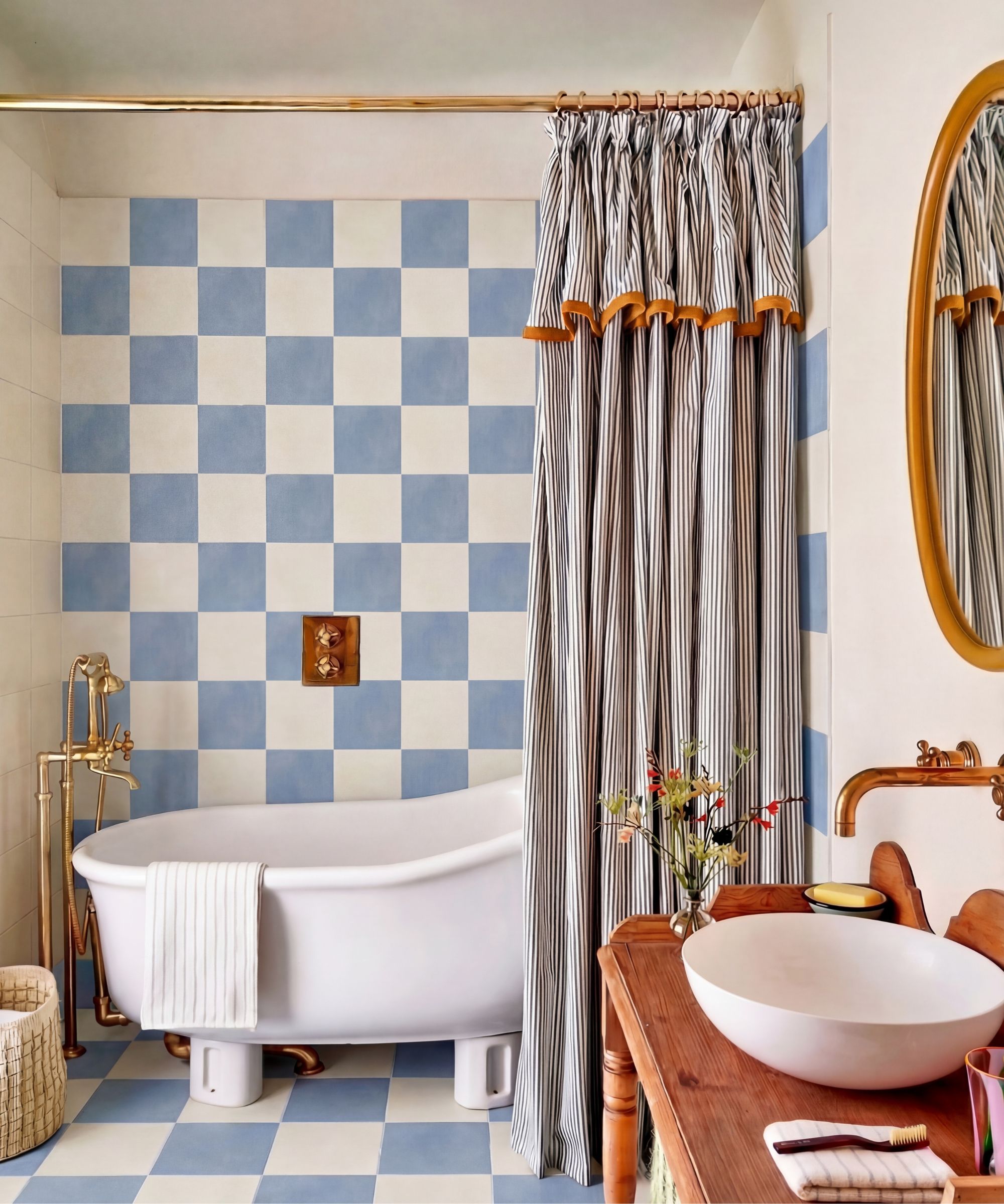 A small bathroom with blue and white checkerboard floor and wall tiles, and a striped curtain creating a bath nook