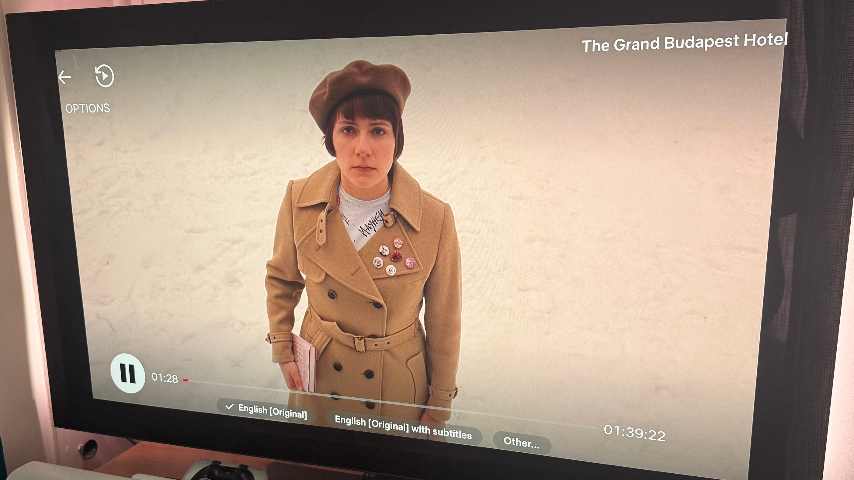 An image from The Grand Budapest Hotel, showing a character on snowy ground. The new Netflix interface is superimposed over the image
