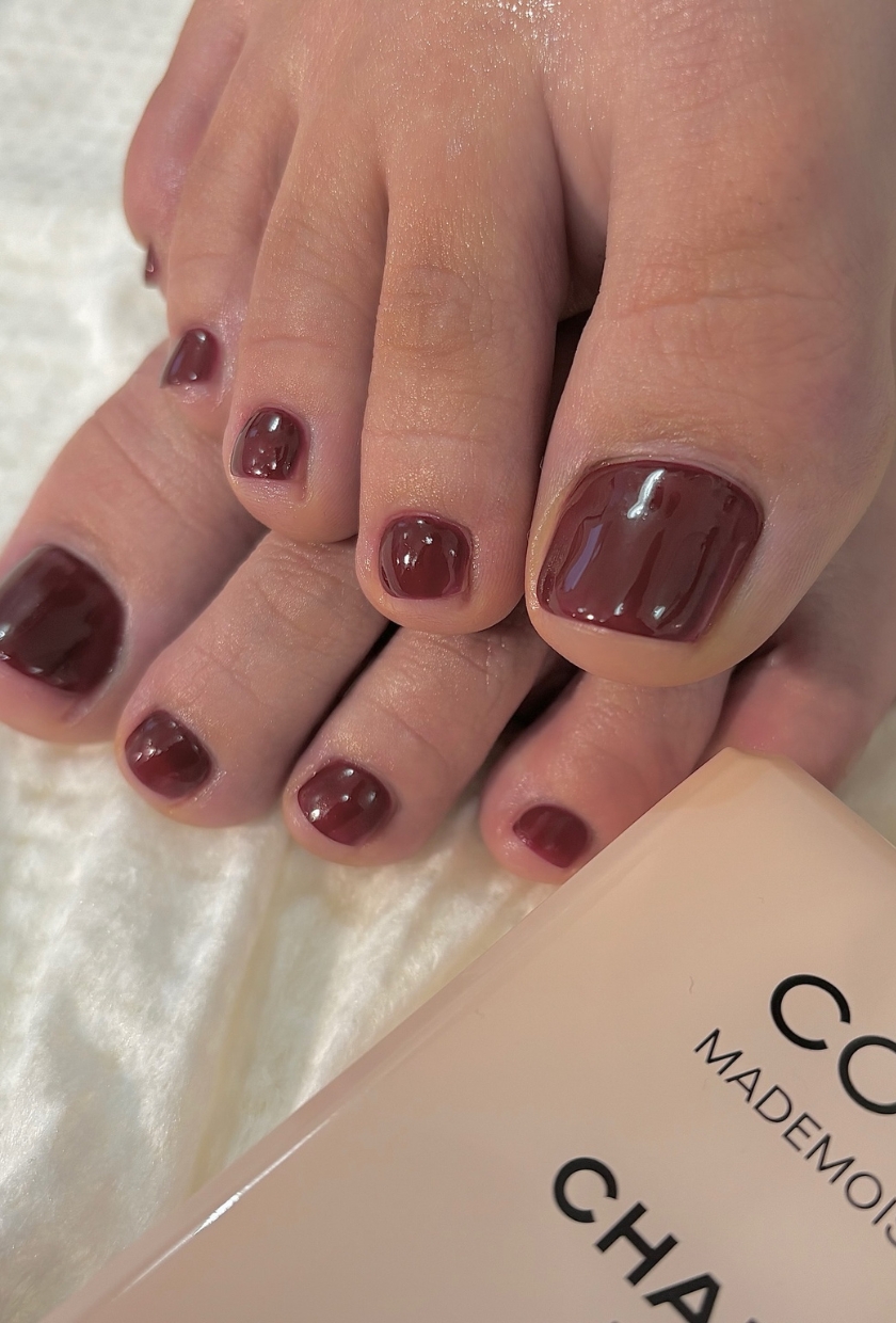 a close-up shot of a dark red pedicure