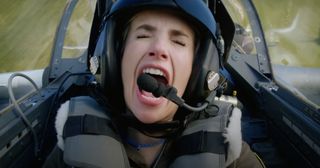 A young woman screams while in a jet airplane