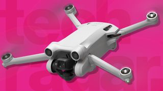 A DJI drone on a pink background