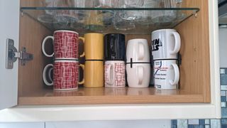 Stacked mugs in kitchen cabinet