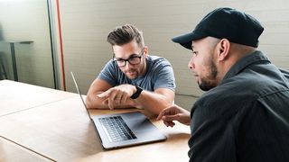 Two men working on a laptop