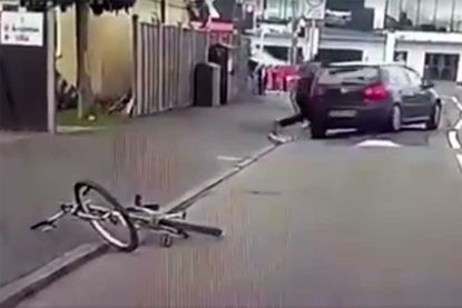 The rider of the bike gets up after being hit by the Volkswagen Golf and smashes the rear windscreen