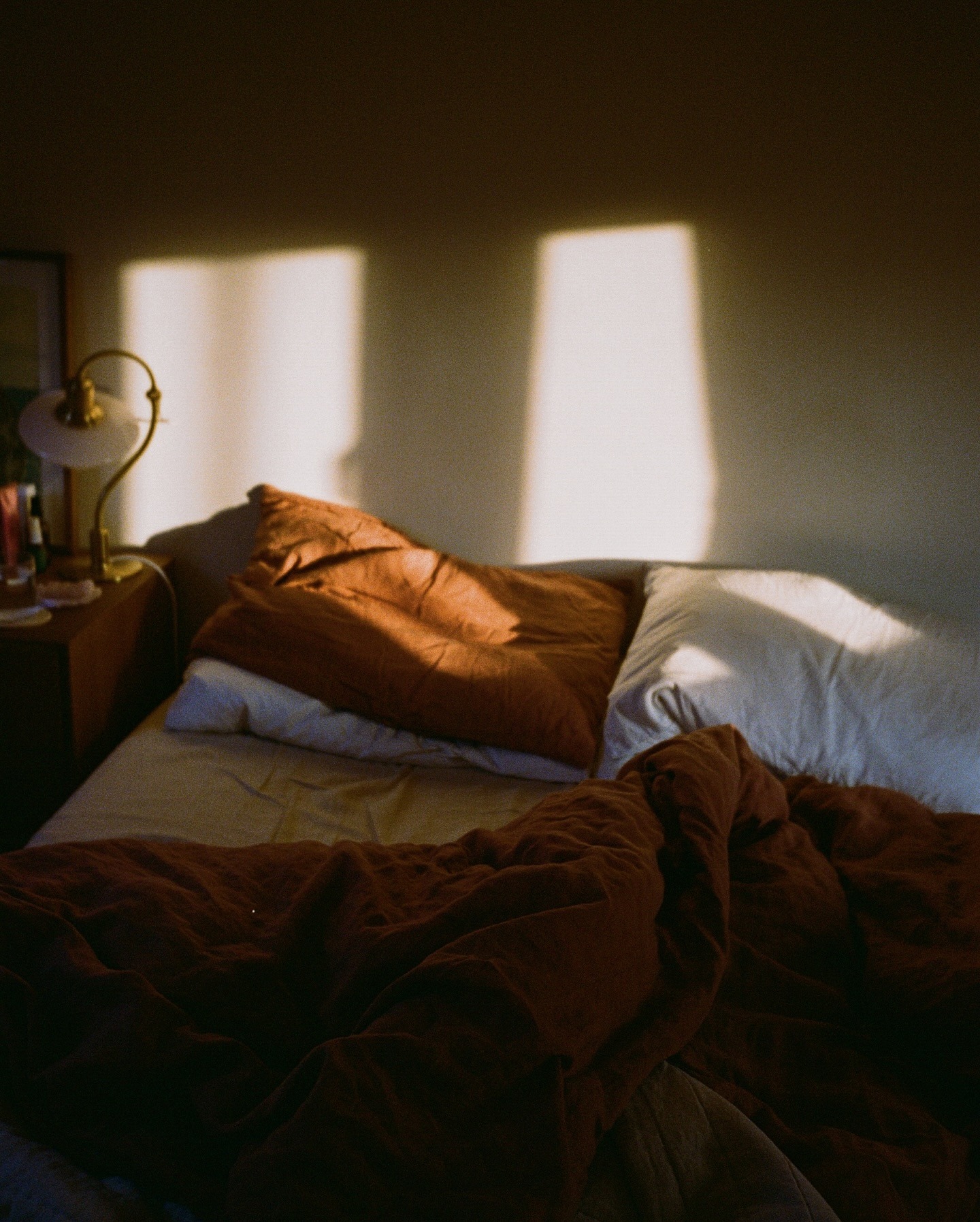 an unmade bed with brown linen bedsheets