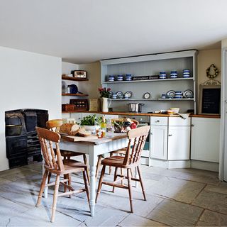 kitchen with white wall and crockery shelf and dining table